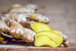 fresh ginger root on wooden board – top herbs for the family kitchen